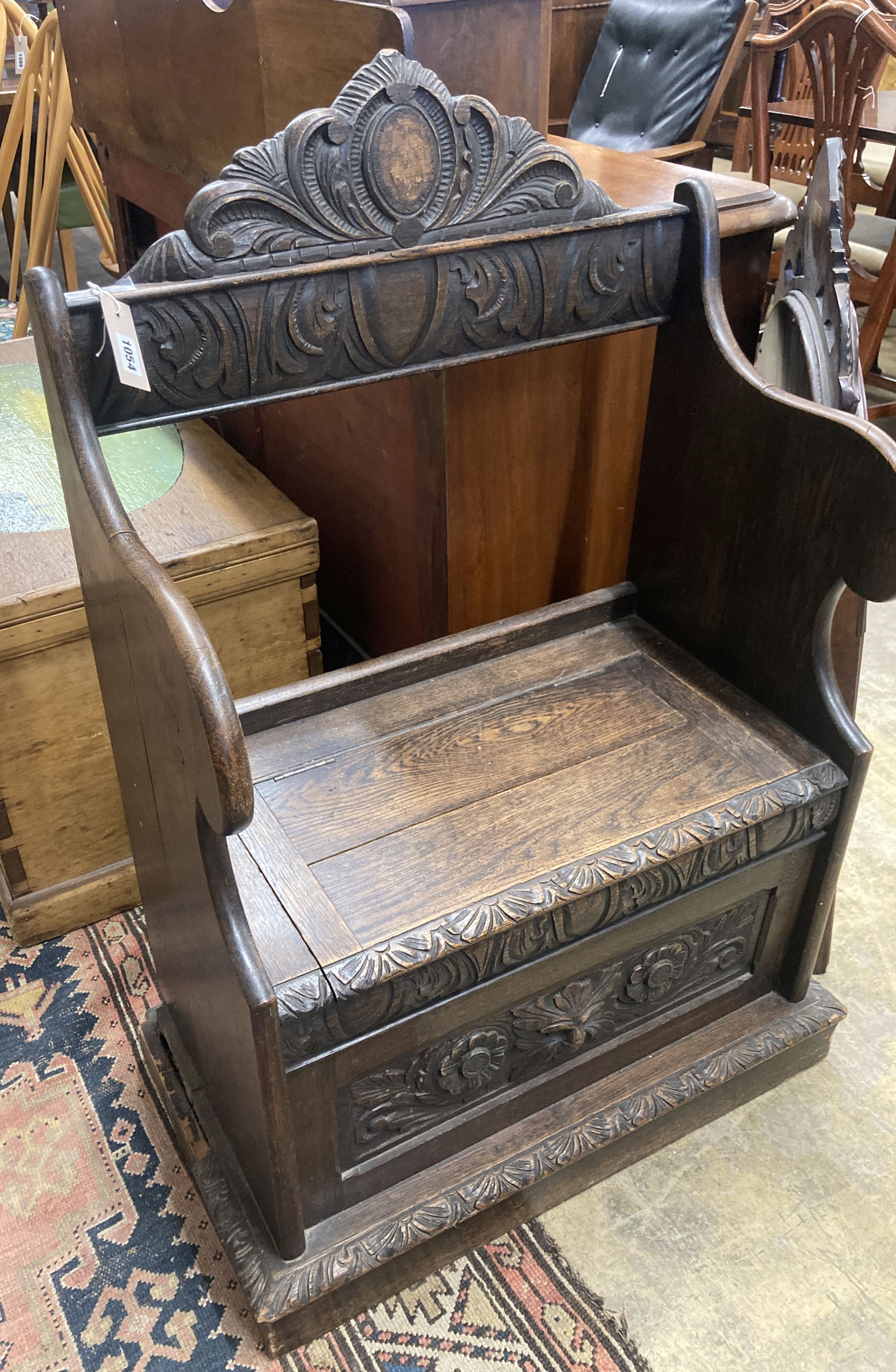 A small Flemish carved oak box seat settle, width 65cm, depth 40cm, height 104cm